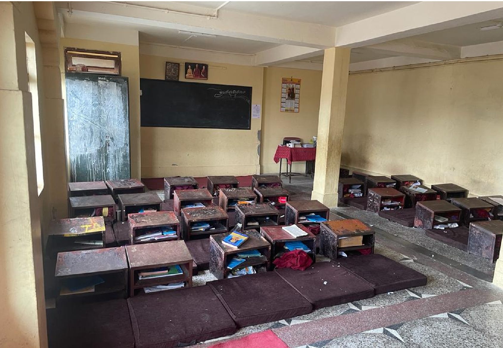 Aula del colegio con pupitres bajos y cojines en el suelo